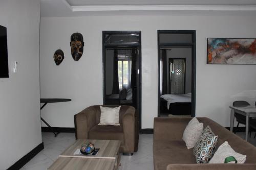 a living room with two couches and a table at MHP Apartments in Munyonyo