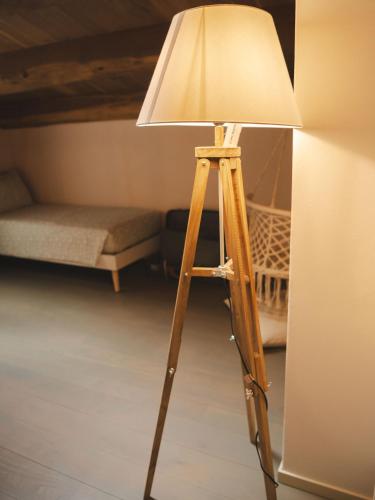 a wooden tripod lamp with a lamp shade on it at Agriturismo Camponovo in Brisighella