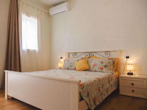 a white bedroom with a bed and a window at Agriturismo Camponovo in Brisighella