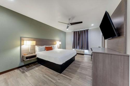 a hotel room with a bed and a flat screen tv at Americas Best Value Inn San Antonio Downtown Riverwalk in San Antonio
