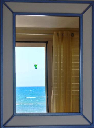 a window in a room with a view of the ocean at Hotel Mar & Sol in Punta Secca