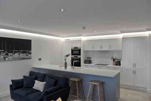 a living room with a blue couch and a kitchen at The Pier Portrush in Portrush