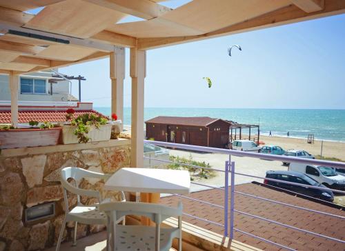 a balcony with a table and chairs and a view of the beach at Hotel Mar & Sol in Punta Secca