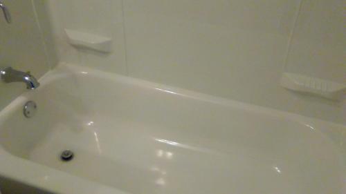 a white bath tub with a faucet in a bathroom at Days Inn by Wyndham Cleveland Lakewood in Lakewood