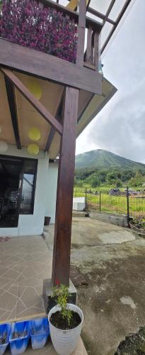 a building with a balcony with flowers on it at Lokon Vila and Camp in Tomohon