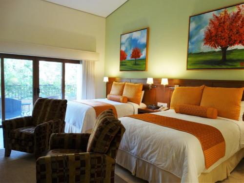 a hotel room with two beds and two chairs at Santuario Diegueño in Tecate