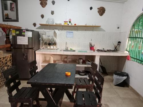 a kitchen with a table and chairs and a refrigerator at CASA BLANCA Hostal in Minca