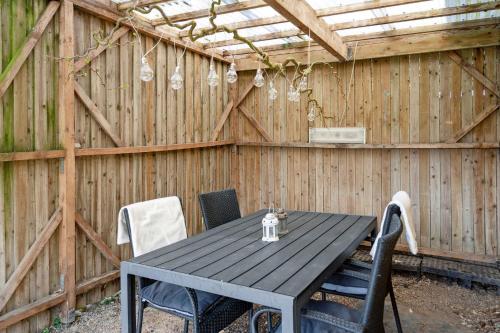 a black table and chairs in a wooden shed at Cozy Holiday Home Near Lillebælt in Haderslev