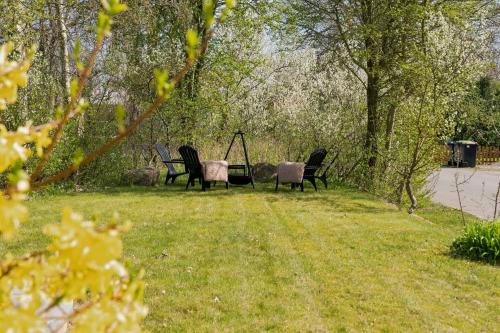 a group of chairs sitting in the grass at Cozy Holiday Home Near Lillebælt in Haderslev