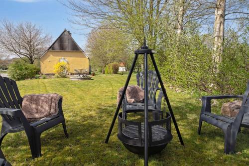 a swing in a yard with two chairs and a house at Cozy Holiday Home Near Lillebælt in Haderslev