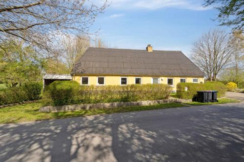 a yellow house with a black roof on a street at Cozy Holiday Home Near Lillebælt in Haderslev