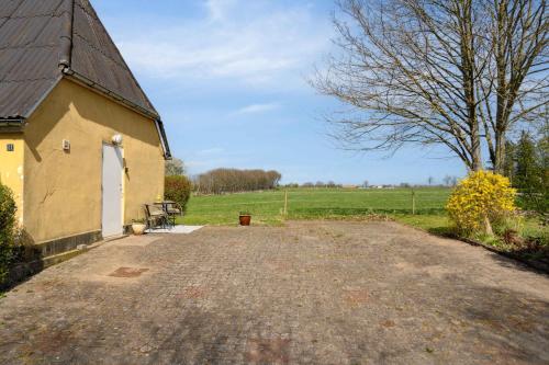 a small yellow building with a bench next to a field at Cozy Holiday Home Near Lillebælt in Haderslev