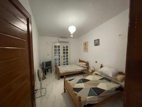 a room with two beds and a tv in it at North coast Great nightlife shoreside Marina AlAlamain مارينا الساحل الشمالي in El Alamein