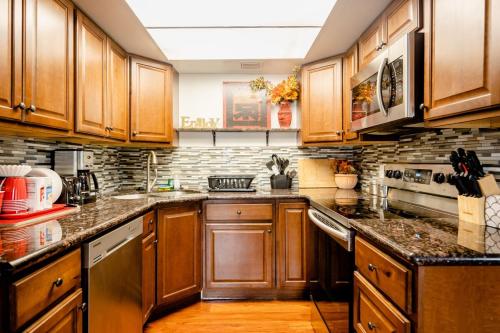 a kitchen with wooden cabinets and granite counter tops at 2 bedroom UNLV, Thomas Mack in Las Vegas