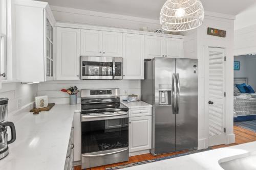 a kitchen with white cabinets and a stainless steel refrigerator at Fripp Island 94 Davis Love Dr in Fripp Island