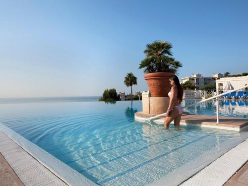 une femme debout dans l'eau à côté d'une piscine dans l'établissement Holiday Paradise, à Cannes