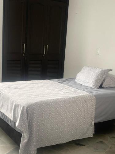 a bed with white sheets and pillows on it at Apartamento amoblado in Neiva