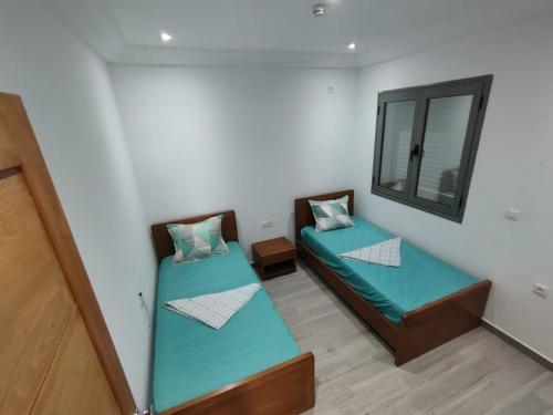 two beds in a room with a mirror at Résidence Inès Djerba Appartements VIP in Houmt Souk