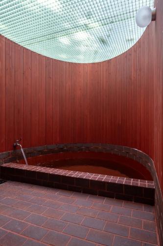 a large tub in a red wall with a ceiling at Private Villa 3 minutes from bus stop - in the meantime in Hakone