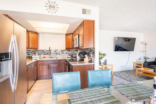 a kitchen with a glass table and blue chairs at MGM Airport Strip 2 miles in Las Vegas