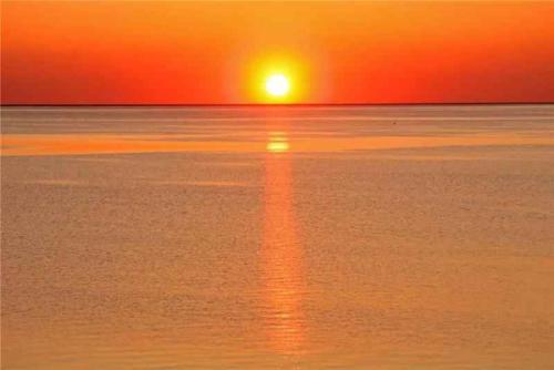 a sunset over the water with the sun setting at Apartment in Paduledda 53780 in Cascabraga