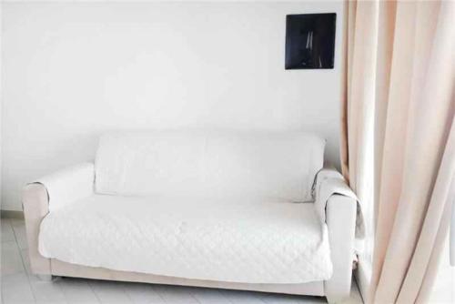 a white couch sitting in a room with a window at Apartment in Paduledda 53780 in Cascabraga