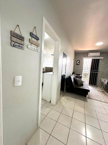 a living room with a couch and signs on the wall at APT Davisis 11 Tom Jobim - Px Praça Girassóis, Av JK e Detran in Palmas