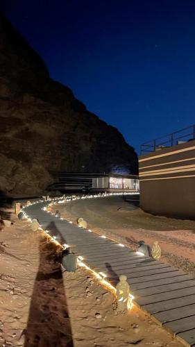 a long line of lights on a beach at night at مخيم خيال رم in Jurf ad Darāwīsh