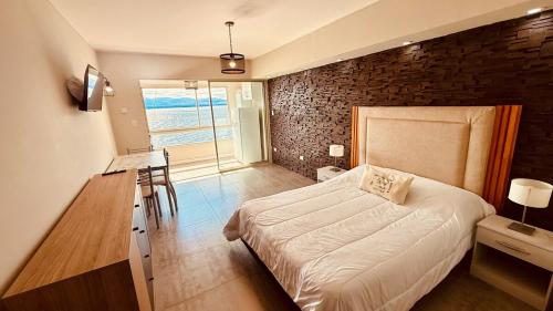 a bedroom with a bed and a brick wall at Departamento a Orilla del Lago in San Carlos de Bariloche