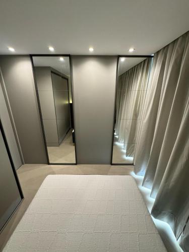a dressing room with mirrors and a white rug at Apartamento Edifício Vista Mare in Torres