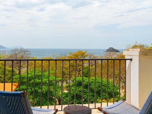 a balcony with chairs and a view of the ocean at Santarena Hotel at Las Catalinas in Playa Flamingo