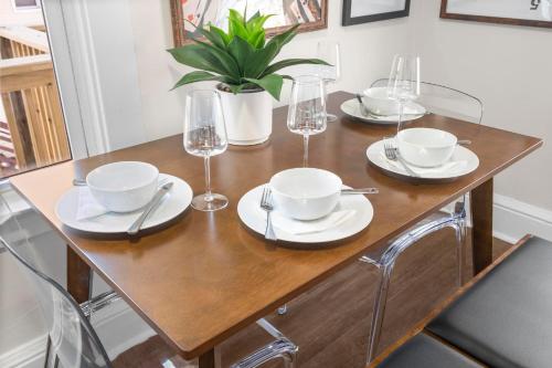 a table with plates and glasses and a plant on it at Royal Flush-6 King Beds-18 Mi To Mohegan in Norwich