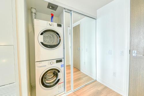 a laundry room with a washer and dryer at RivetStays - The Jarvis in Toronto