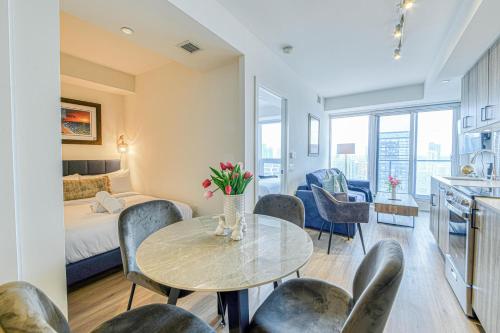 a room with a bed and a table and chairs at RivetStays - The Jarvis in Toronto