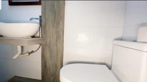 a bathroom with a white toilet and a sink at Casa Hospedaje terraza con vista a La Merced in La Merced