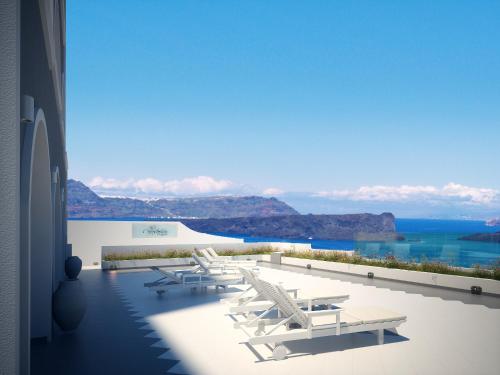 a row of white chairs and tables on a building at Acrothea Suites and Villas in Akrotiri