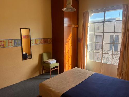 a bedroom with a bed and a window at Puebla en familia in Puebla