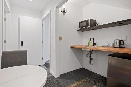 una pequeña cocina blanca con fregadero y microondas en Peaceful 1BR Stay - Golf & Beach, en Pacífica