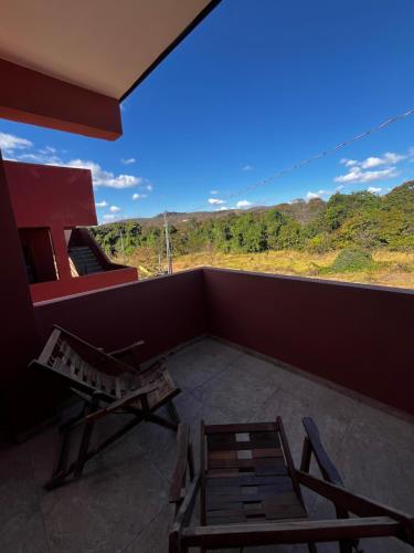 a balcony with a table and chairs and a view at Mokambo da Serra in Alto Paraíso de Goiás