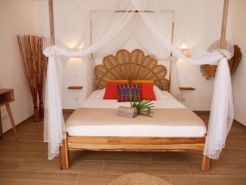 a bedroom with a bed with a canopy at Coco Soley in Le Diamant