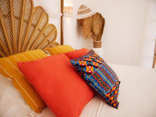 a pile of pillows sitting on a bed at Coco Soley in Le Diamant