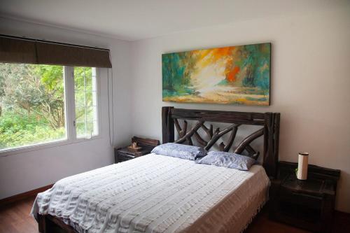 a bedroom with a bed and a painting on the wall at Villa in the Forest - Mont Ventoux in Cali
