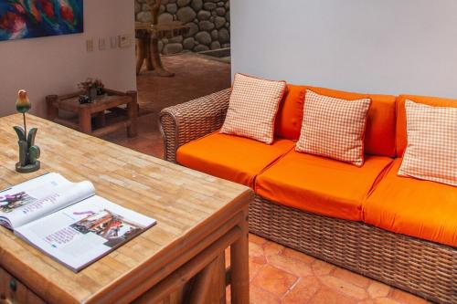 a living room with an orange couch and a table at Villa in the Forest - Mont Ventoux in Cali
