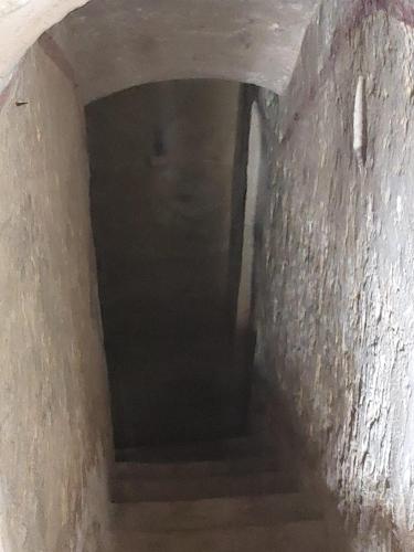 a dark hallway with stairs in a stone tunnel at Kanina in Mellieħa