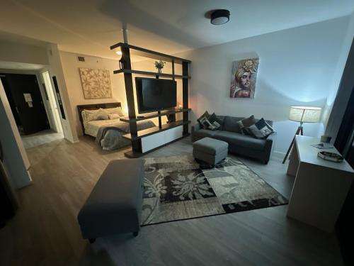 a living room with a couch and a tv at Luxe Ventures Miami in Miami