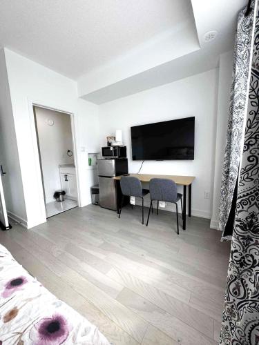 a room with a desk and a table with chairs at Modern Private Room Private Bathroom with King Bed with TV and Optional Balcony 10 minutes to Rogers Stadium Midtown Downtown Toronto in Toronto