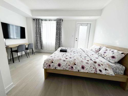 a bedroom with a bed and a desk in it at Modern Private Room Private Bathroom with King Bed with TV and Optional Balcony 10 minutes to Rogers Stadium Midtown Downtown Toronto in Toronto