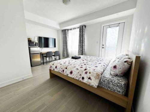 a bedroom with a bed and a room with a kitchen at Modern Private Room Private Bathroom with King Bed with TV and Optional Balcony 10 minutes to Rogers Stadium Midtown Downtown Toronto in Toronto