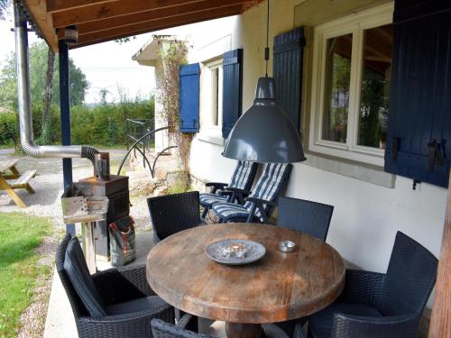 a wooden table and chairs on a patio at Holiday Home in St Honoré with Scenic Views in Saint-Honoré-les-Bains