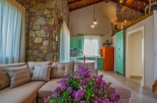 a living room with a couch and a stone wall at Mediterraneo Luxury Suites Halkidiki in Vourvourou